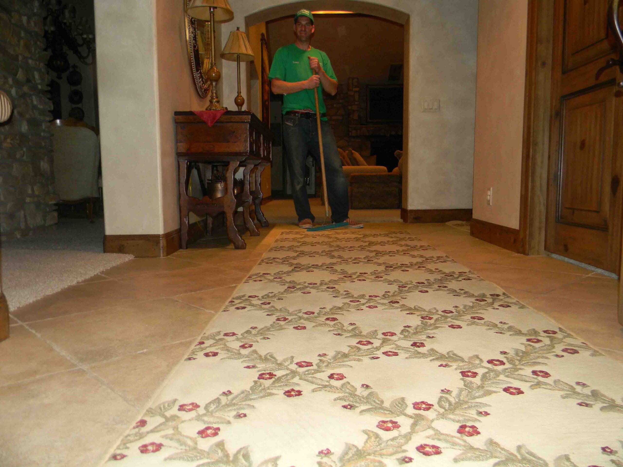 On-The-Spot Cleaning Services - Owner, Tony, standing in the entryway of a mansion. He has cleaned, dried, and brushed the carpet clean.